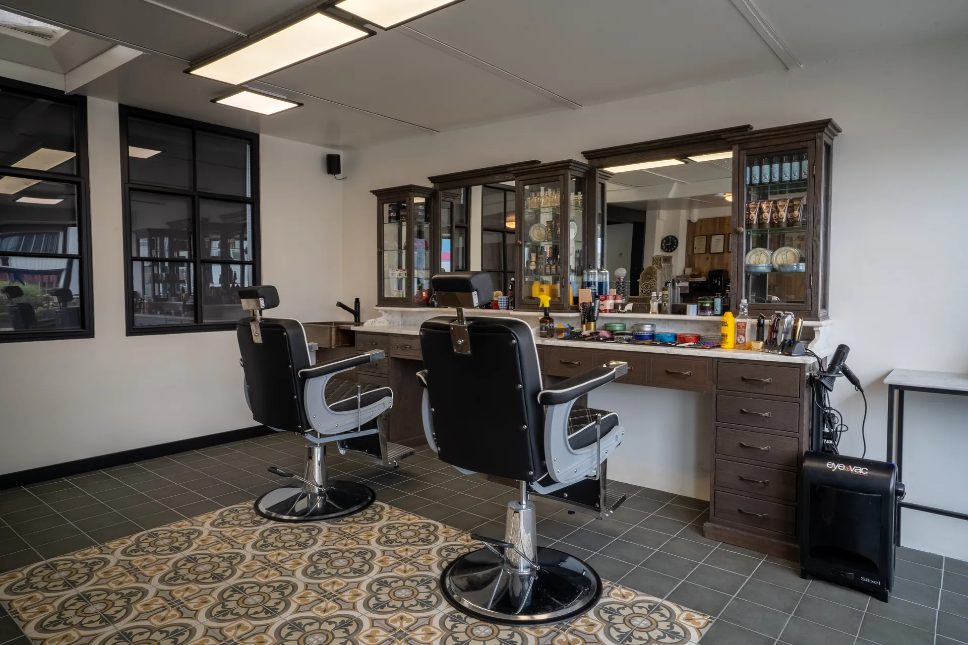 Het interieur van Barbershop Olle met klassieke barberstoelen en houten spiegels